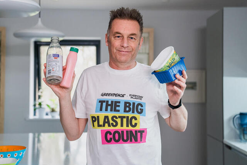 Chris Packham in his kitchen holding plastic 