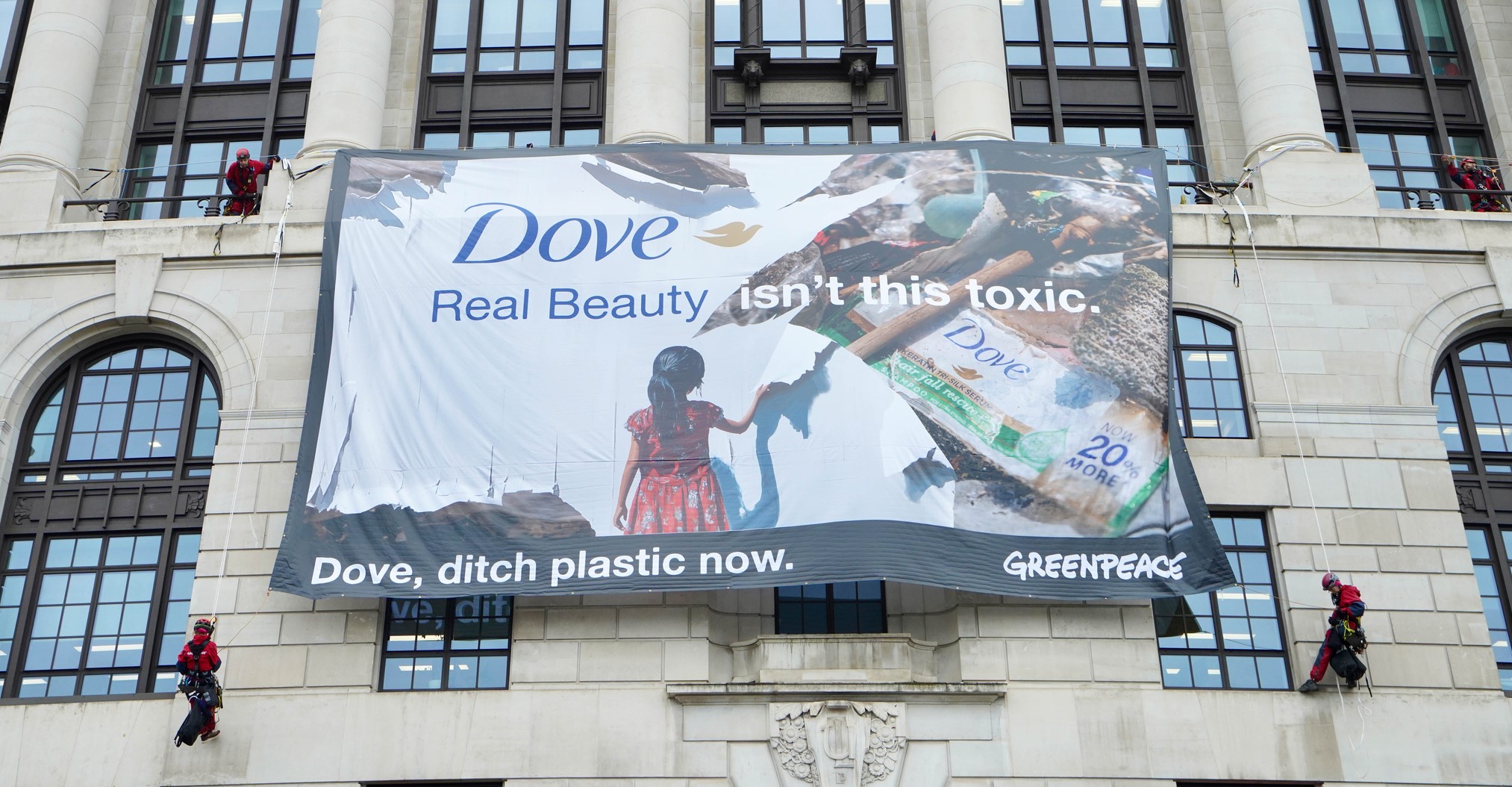 Greenpeace activists scaled Dove headquarters to reveal a banner that says: Real Beauty isn't this toxic. Dove, ditch plastic now.